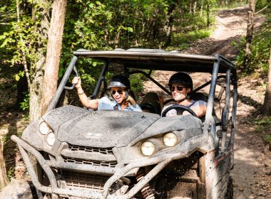 A couple ATVs along a dirt trail through the woods at Shephard of the Hills in Branson, Missouri.