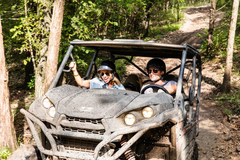 A couple ATVs along a dirt trail through the woods at Shephard of the Hills in Branson, Missouri.