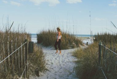 A woman walks along a path towards a secluded beach on Hilton Head Island.