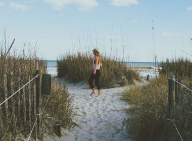 A woman walks along a path towards a secluded beach on Hilton Head Island.