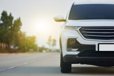 Front view of a white SUV on a paved road.