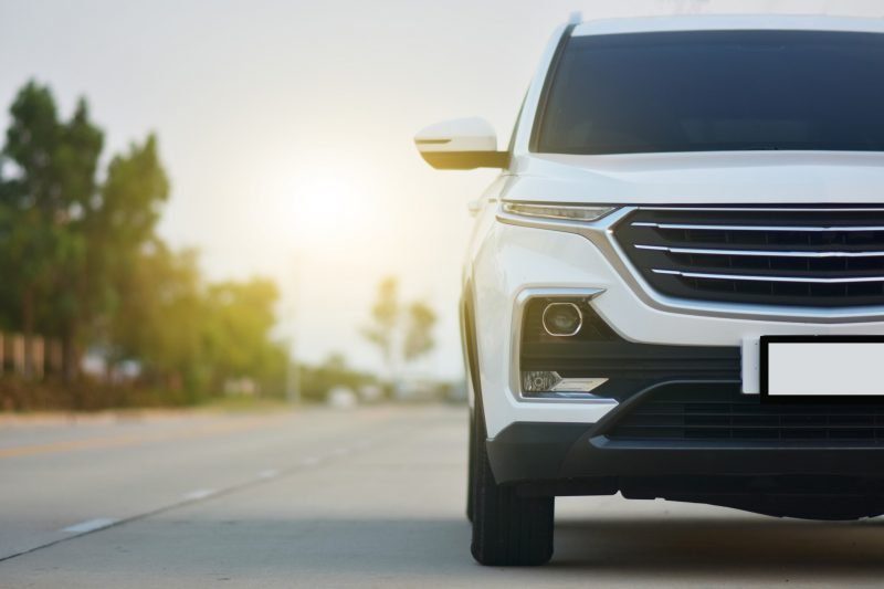 Front view of a white SUV on a paved road.