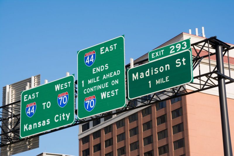 Interstate signs over the road in a downtown metro area.