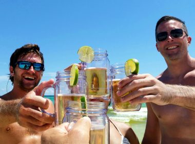 Dude hanging out on the beach with mugs of beer