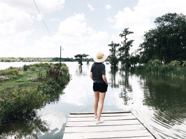 A woman stands on the edge of a dock overlooking Lake Martin in the small town of Breaux Bridge, Louisiana.