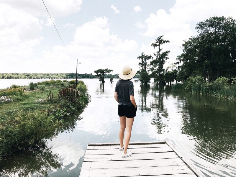 A woman stands on the edge of a dock overlooking Lake Martin in the small town of Breaux Bridge, Louisiana.