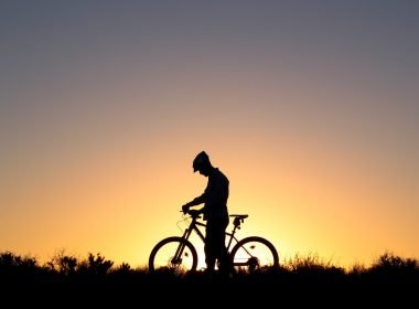 The silhouette of a bicyclist against a sunset