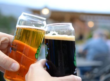Two friends cheers their craft beers together.