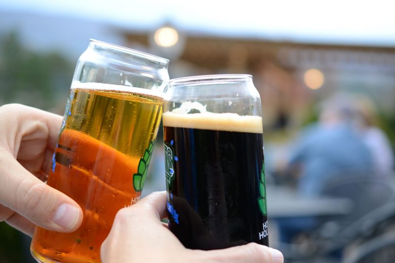 Two friends cheers their craft beers together.