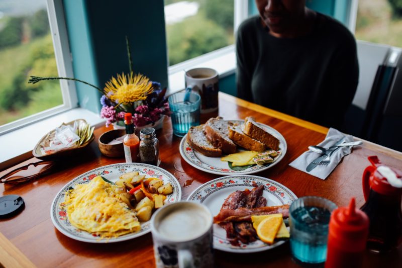 Two diners enjoying omelettes for breakfast while traveling.