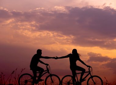 Two people biking at sunset