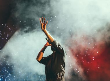 Lead singer performing at a live outdoor concert venue