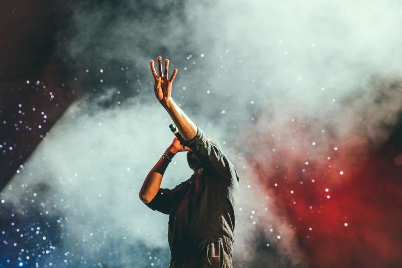 Lead singer performing at a live outdoor concert venue