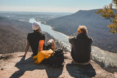 Two friends sit on a rock overlooking the Tennessee River
