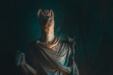 A statue of Anubis, the God of Embailming and Funerals, in a dark room.