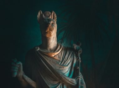 A statue of Anubis, the God of Embailming and Funerals, in a dark room.