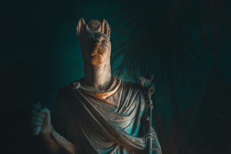 A statue of Anubis, the God of Embailming and Funerals, in a dark room.