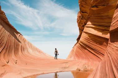 A man look up in awe at the rock formations along the Wave Trail in Kanab, Utah.