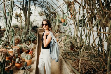 A woman in a cactus green house in a botannical garden in California