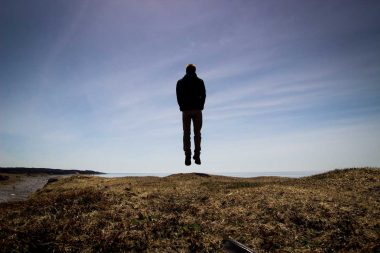 A man floating out in nature against the sky.