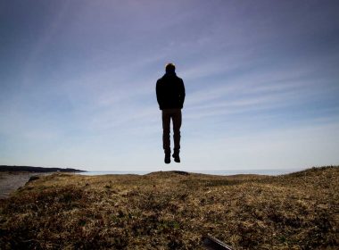 A man floating out in nature against the sky.