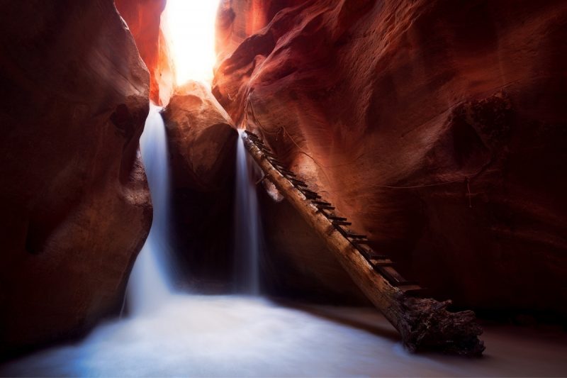 Kanarraville Falls pours into a canyon made of red rock in Utah.