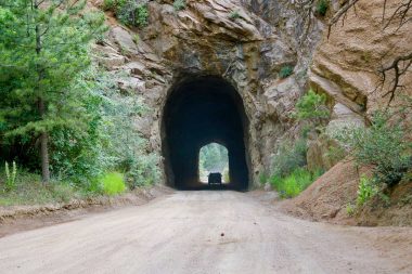 A card dives through a tunnel carved through rock along Gold Camp Road in Colorado Springs