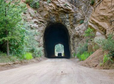 A card dives through a tunnel carved through rock along Gold Camp Road in Colorado Springs