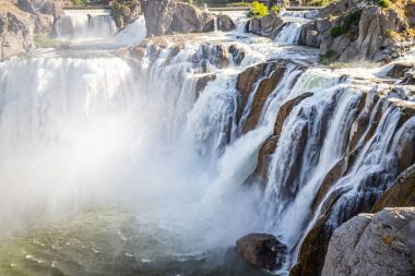 Sun shining through mist churned up by the Shoshone Falls in Idaho.