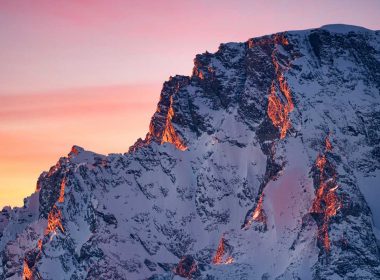 A pink and orange sunset over the Grand Teton Mountain Range in Wyoming.