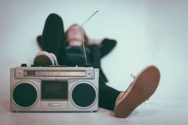 A woman laying down with her foot near a stereo