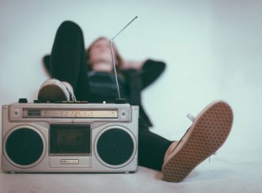 A woman laying down with her foot near a stereo