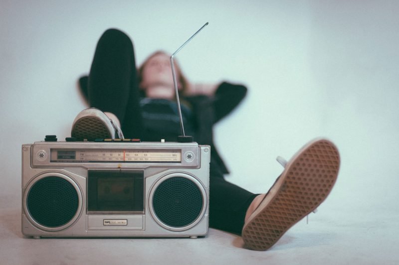 A woman laying down with her foot near a stereo