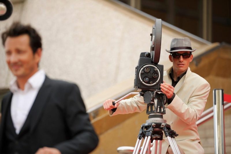 Camera operator filming an actor on set.
