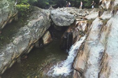 A group of friends walk above the lower Bolten Pothole in the Green Mountain National Forest.
