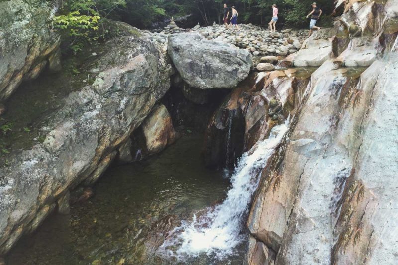 A group of friends walk above the lower Bolten Pothole in the Green Mountain National Forest.