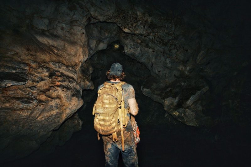 Exploring a dark, abandoned tunnel with flashlights at night.