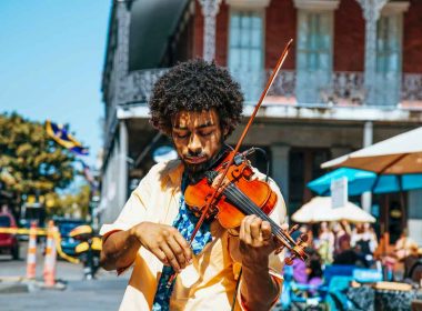 A musician plays his violin on the street in New Orleans, The Big Easy, on a beautiful sunny day.
