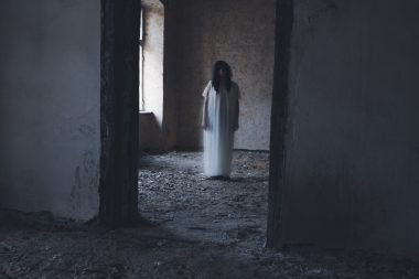 Female ghost walking through a room in The Conjuring house