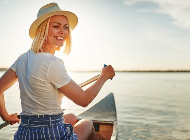 Woman rowing boat along lake in Connecticut