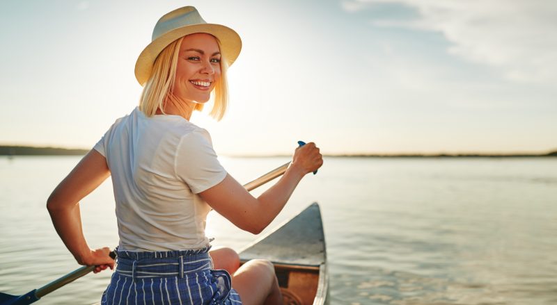 Woman rowing boat along lake in Connecticut
