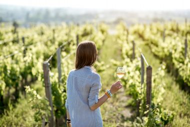 Woman walking among vineyards with a glass of wine on the Connecticut Wine Trail