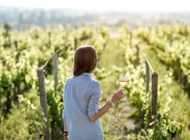 Woman walking among vineyards with a glass of wine on the Connecticut Wine Trail