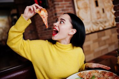Woman eating pizza in Old Forge, PA