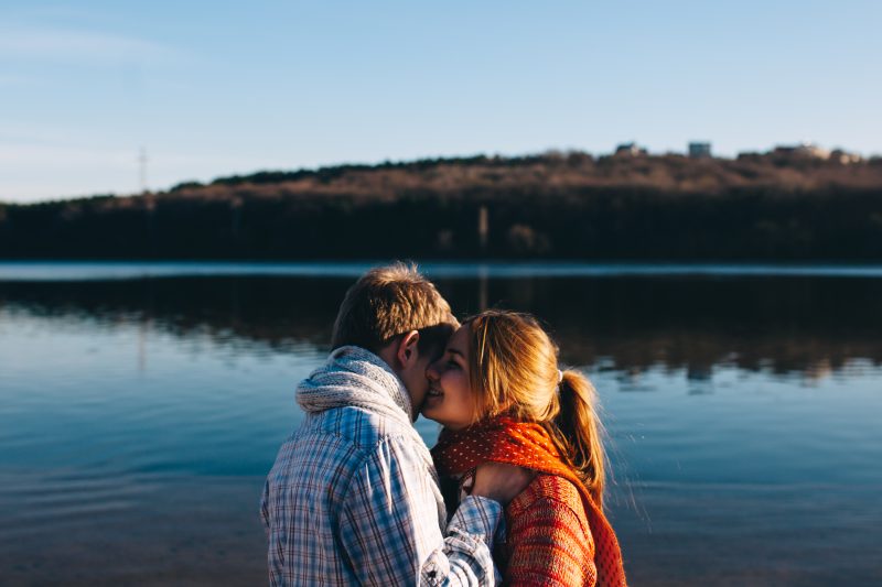 Couple kissing in front of lake in Pennsylvania