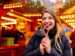 Woman eating candy cane at a Christmas market in NYC