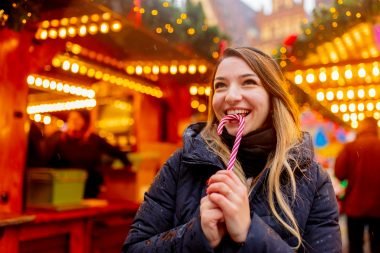 Woman eating candy cane at a Christmas market in NYC