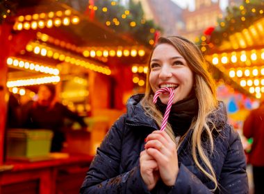 Woman eating candy cane at a Christmas market in NYC